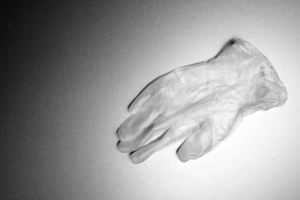 disposable medical transparent glove on a gray background with gradient