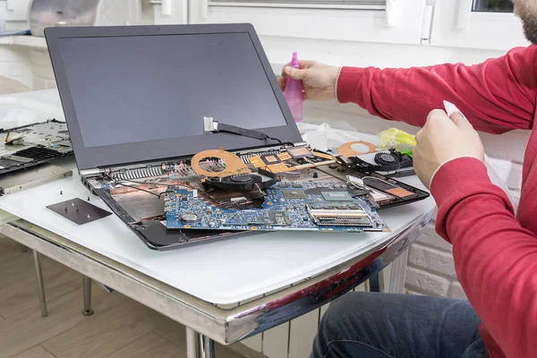 disassembled dusty laptop. the master cleans the processor