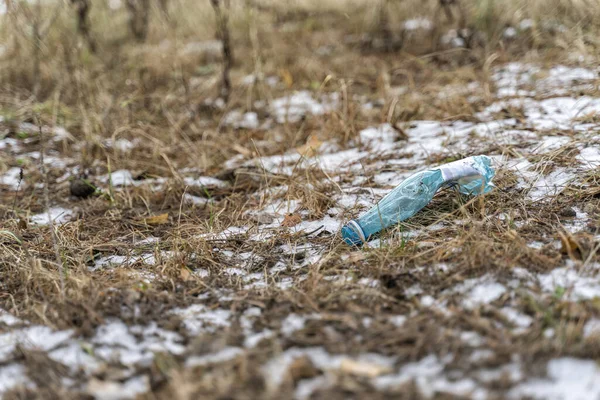 plastic bottle lying on the ground in the forest. the problem of forest pollution by tourists