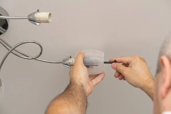 man changes a light bulb in a lighting device, lamp twist.