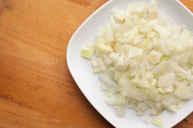 Ahşap doku üzerinde bir tabakta soğan dilimlenmiş