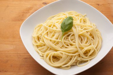 Spagetti ile fesleğen ahşap doku plaka üzerinde