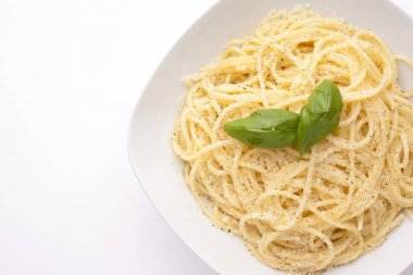 Beyaz bac üzerinde bir tabakta fesleğen ve parmesan peynirli spagetti