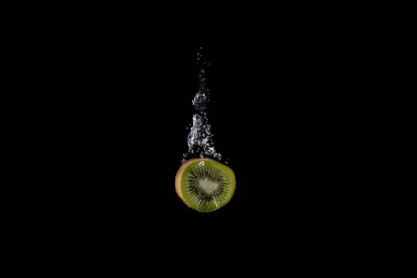 Fruits frais tombés dans l'eau avec éclaboussure sur fond noir — Photo