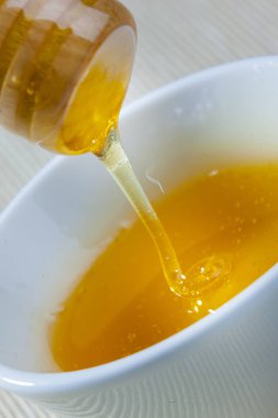 Bal ve bir tahta kaşık ile seramik kase