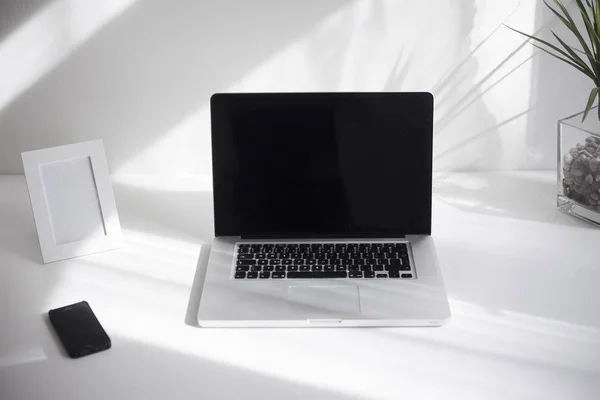 Laptop on the white desk with white background