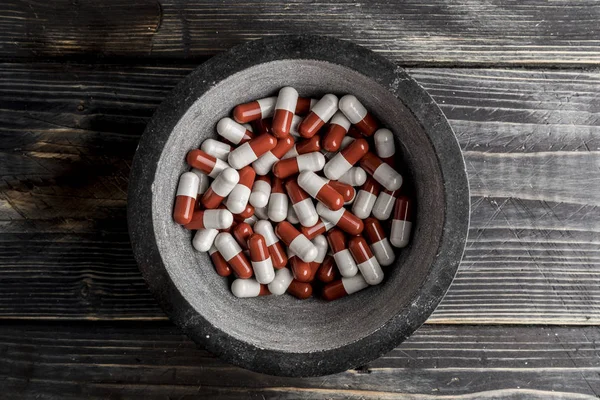 pills in the bowl on wood background. pills addiction concept