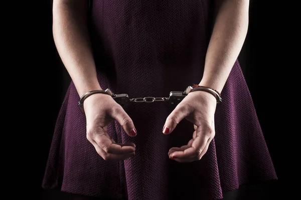 Submissive woman wearing a purple dress in metal handcuffs on bl — Stock Photo, Image