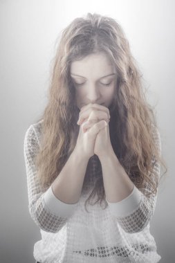 Parlatıcı ile beyaz arka plan üzerinde dua eden kadın.