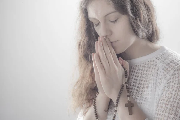 Praying woman on white background with shine.