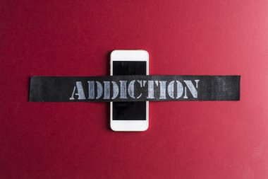 Akıllı telefon bağımlılık kavramı kırmızı zemin üzerine