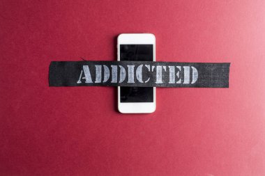 Akıllı telefon bağımlılık kavramı kırmızı zemin üzerine