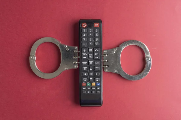 TV addiction concept with tv remote with handcuff