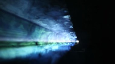 Projektörün renkli ışınları arka sis içinde parlayan  