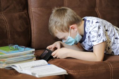 Bir çocuk karantina, salgın sırasında kendi kendini eğitme, evde eğitim gibi dersler alır.