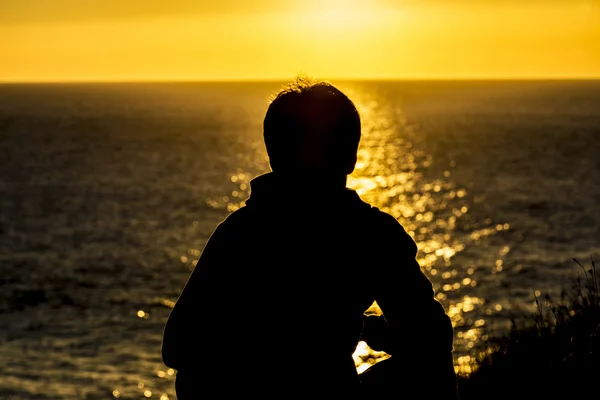 Silhouette of a teenager boy on sunset — Stock Photo, Image