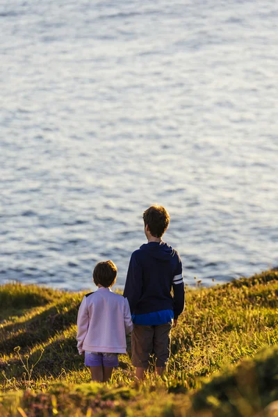 Little girl and teenager boy on sunset — Stock Photo, Image