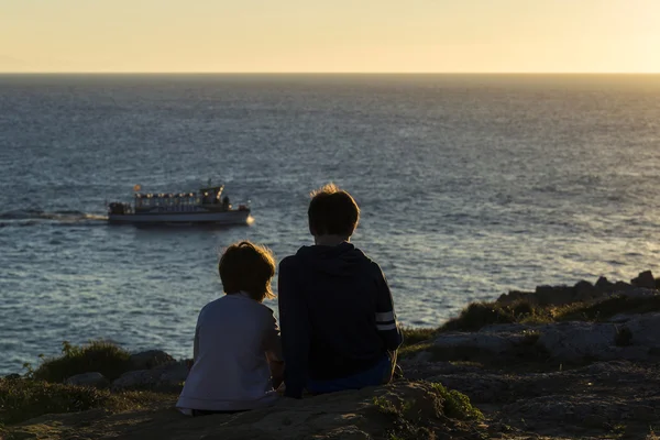 Kleine meisje en tiener jongen op zonsondergang — Stockfoto