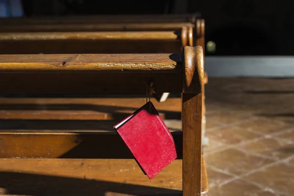 Bijbel opknoping op een houten bankje in een kerk — Stockfoto