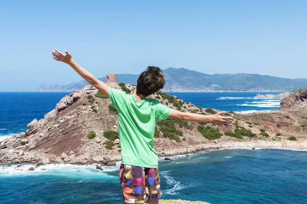Adolescente estirando sus brazos frente al mar en Cerdeña — Foto de Stock