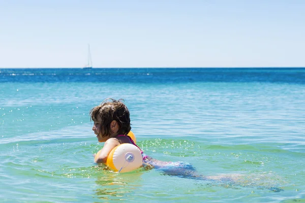 小女孩与一个浮动在海滩上沐浴 — 图库照片
