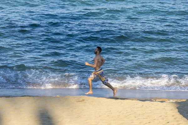 Młody człowiek biegający po plaży — Zdjęcie stockowe