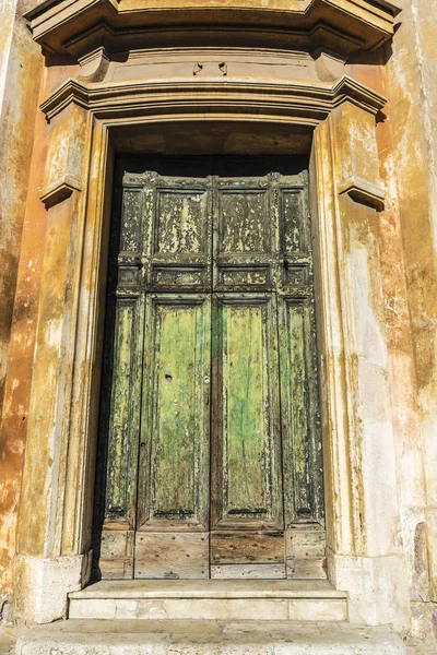 Puerta de madera rajada verde vieja en un edificio clásico —  Fotos de Stock