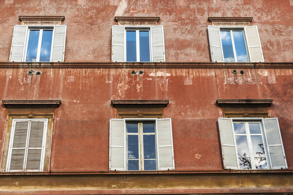 Facade of an old classic building with six windows in the historical center of Rome, Italy