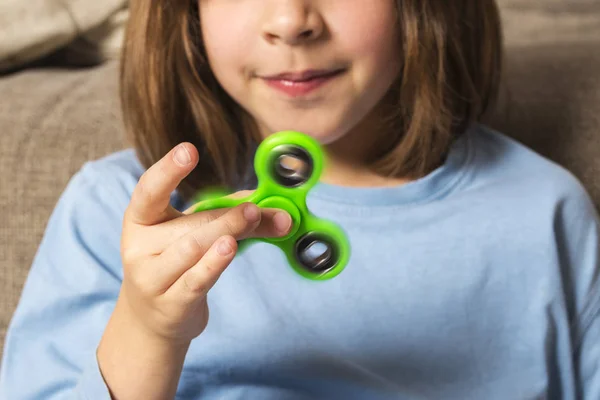 Niña jugando con verde fidget spinner juguete — Foto de Stock