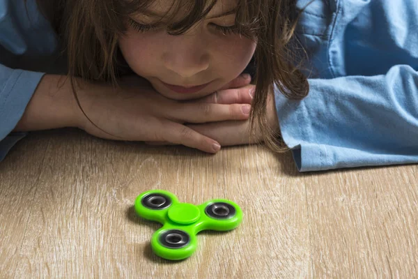 Küçük kız yeşil topluca spinner oyuncakla oynamak