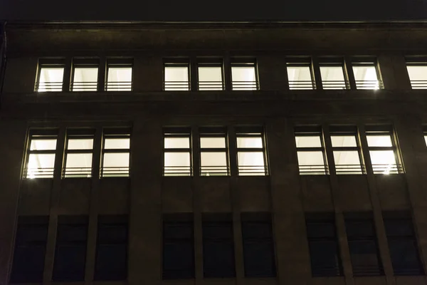 オフィスビルの明かりのついた窓との夜 — ストック写真