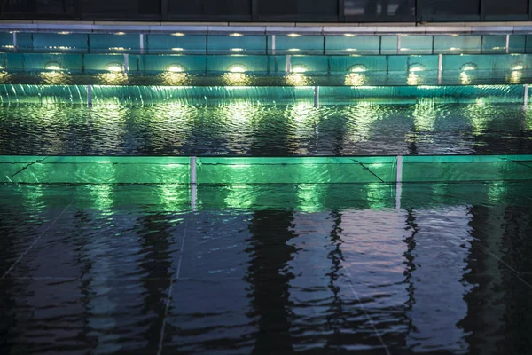 Luzes verdes em uma fonte à noite como fundo abstrato — Fotografia de Stock