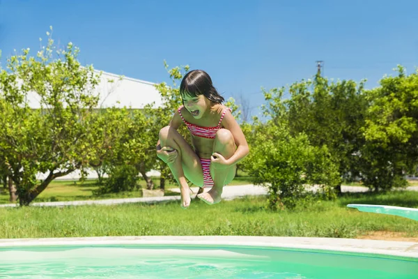 Little girl jumping in pump in an outdoor pool — Stock Photo, Image