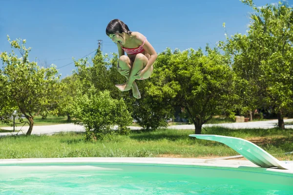 Little girl jumping in pump in an outdoor pool — Stock Photo, Image