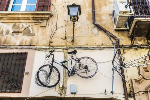 Vélo suspendu à un vieux mur à Palerme, Sicile, Italie — Photo