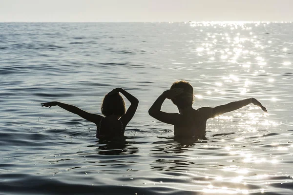 Ragazza e ragazzo che fanno il bagno e ballano in mare in estate — Foto Stock