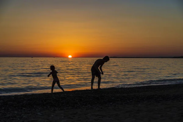 小女孩和青少年在海滩上玩日落 — 图库照片