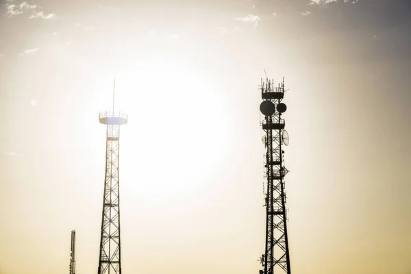 Silhouetten van telecommunicatie torens bij zonsondergang — Stockfoto