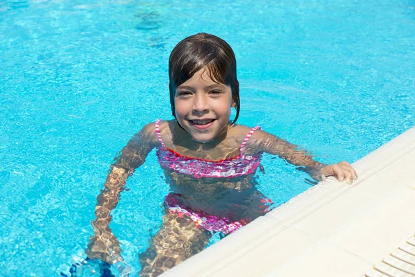 Usměvavá holčička se dívá na kamery ve venkovním bazénu — Stock fotografie