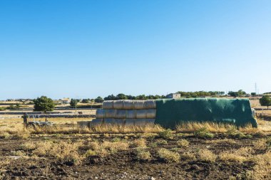 Traktör ve saman balya arasında kırpma alanları Sicilya, İtalya