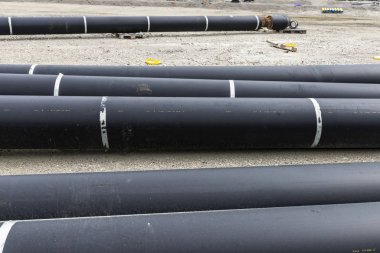 İnşaat alanındaki büyük siyah borular.