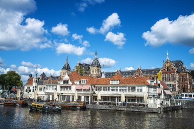 Amsterdam, Hollanda - 7 Eylül 2018: Bir kanal ve Amsterdam Centraal istasyonunun yanındaki Cafe Restoranı Loetje Centraal cephesi
