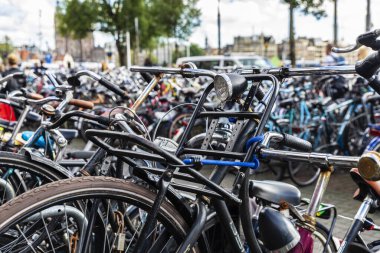 Amsterdam, Hollanda 'nın ortasında arka arkaya park etmiş bisikletlerle dolu büyük bir bisiklet parkı.
