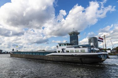Hollanda, Amsterdam 'da büyük bir kargo gemisi nehirde yol alıyor.
