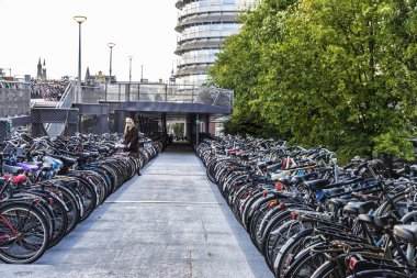 Amsterdam, Hollanda - 7 Eylül 2018: Amsterdam, Hollanda 'nın merkezinde bir kızla peş peşe park etmiş bisikletlerle dolu büyük bir bisiklet park alanı