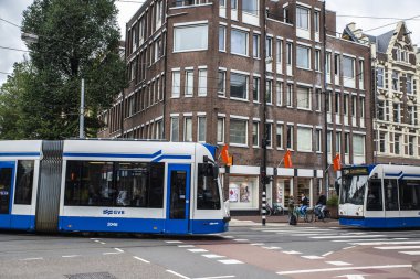 Amsterdam, Hollanda - 8 Eylül 2018: Amsterdam, Hollanda 'nın eski tarihi merkezinde tramvay ve bisikletli insanlar