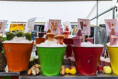Amsterdam, Hollanda - 8 Eylül 2018: Hollanda, Amsterdam 'da sokak gıda pazarı Albert Cuyp Market' te bir meyve ve sebze dükkanında renkli küplerle meyve suyu ve smoothie