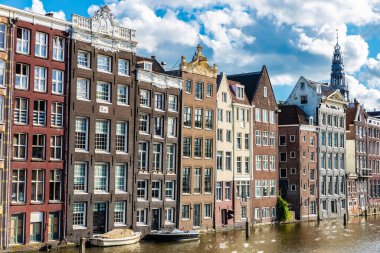Damrak Rıhtımı, Amsterdam, Hollanda 'da bir kanal boyunca eski geleneksel eğimli evler