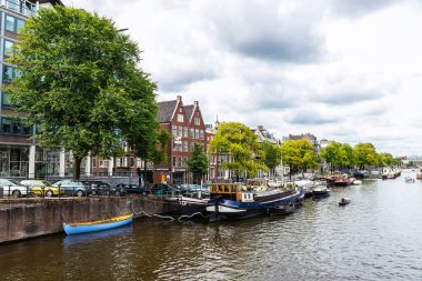 Amsterdam, Hollanda - 8 Eylül 2018: Hollanda, Amsterdam 'da bir kanal boyunca demirlemiş tekneler ve gemiler