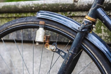 Hollanda, Amsterdam 'da bir sokağa park edilmiş paslı eski bir bisikletin dinamosu.